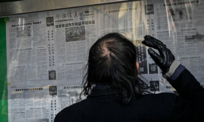A man reads a Chinese state-run newspaper with coverage of Russia's invasion of Ukraine, that supports Russia’s actions, on a street in Beijing, China on Feb. 24, 2022. (Jade Gao/AFP via Getty Images)