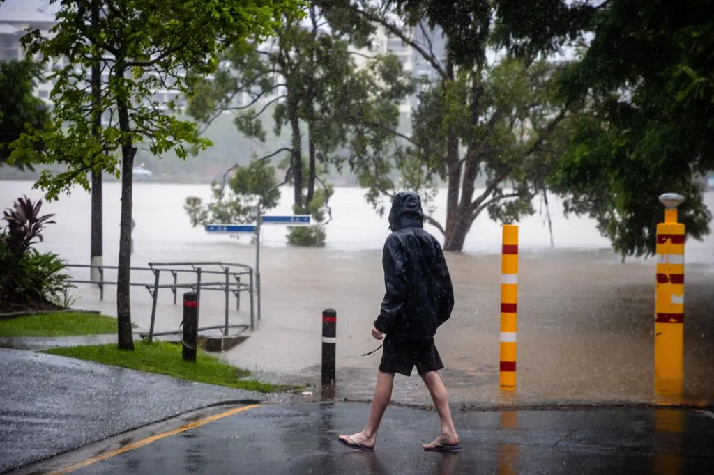 A man watches as the water level of the flooded Brisbane River rises at West End, Australia, on Feb. 27, 2022. (Patrick Hamilton/AFP via Getty Images)
