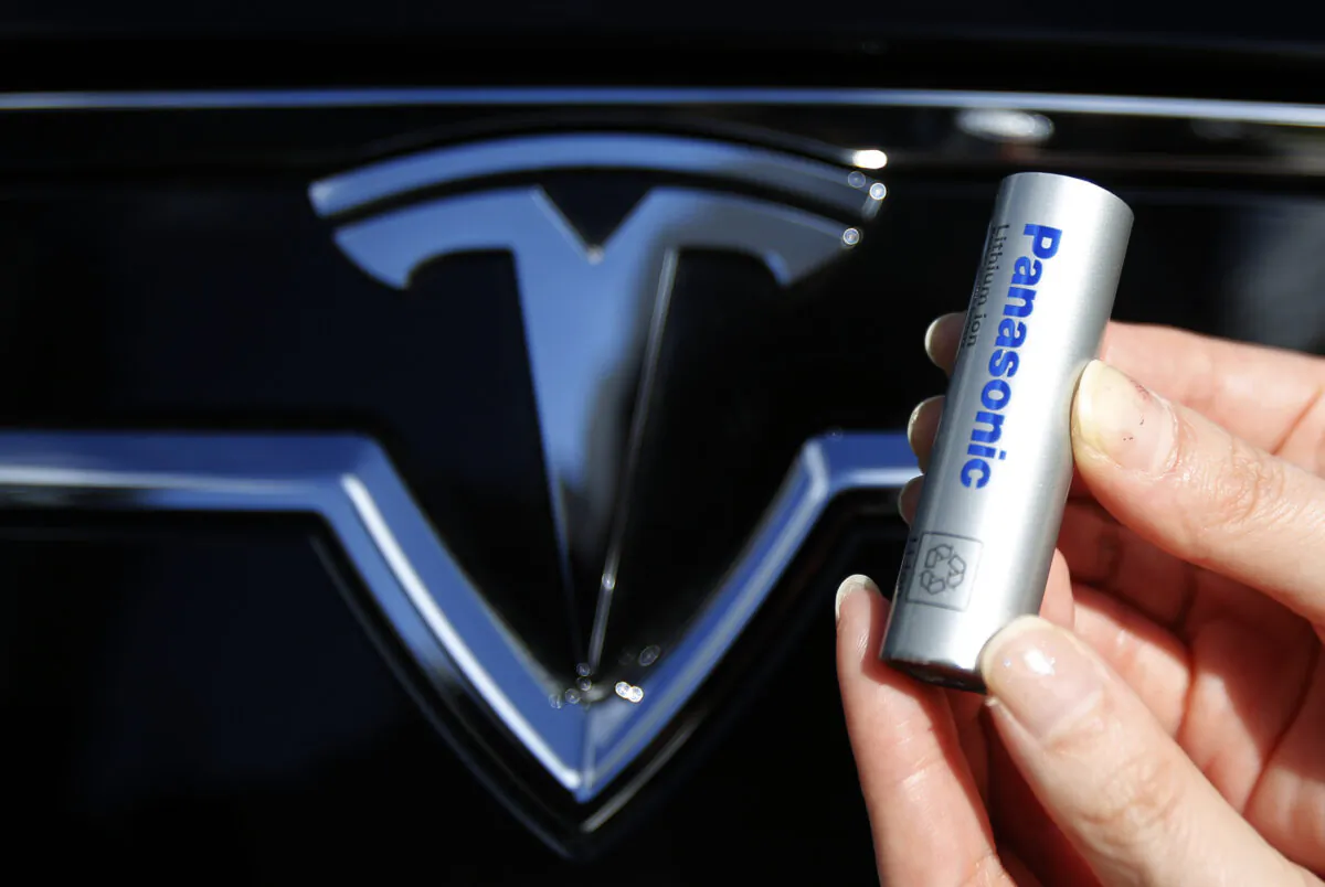 A Panasonic Corp.'s lithium-ion battery, which is part of Tesla Motor Inc.'s Model S and Model X battery packs, is pictured with Tesla Motors logo at the Panasonic Center in Tokyo on Nov. 19, 2013. (Yuya Shino/Reuters)