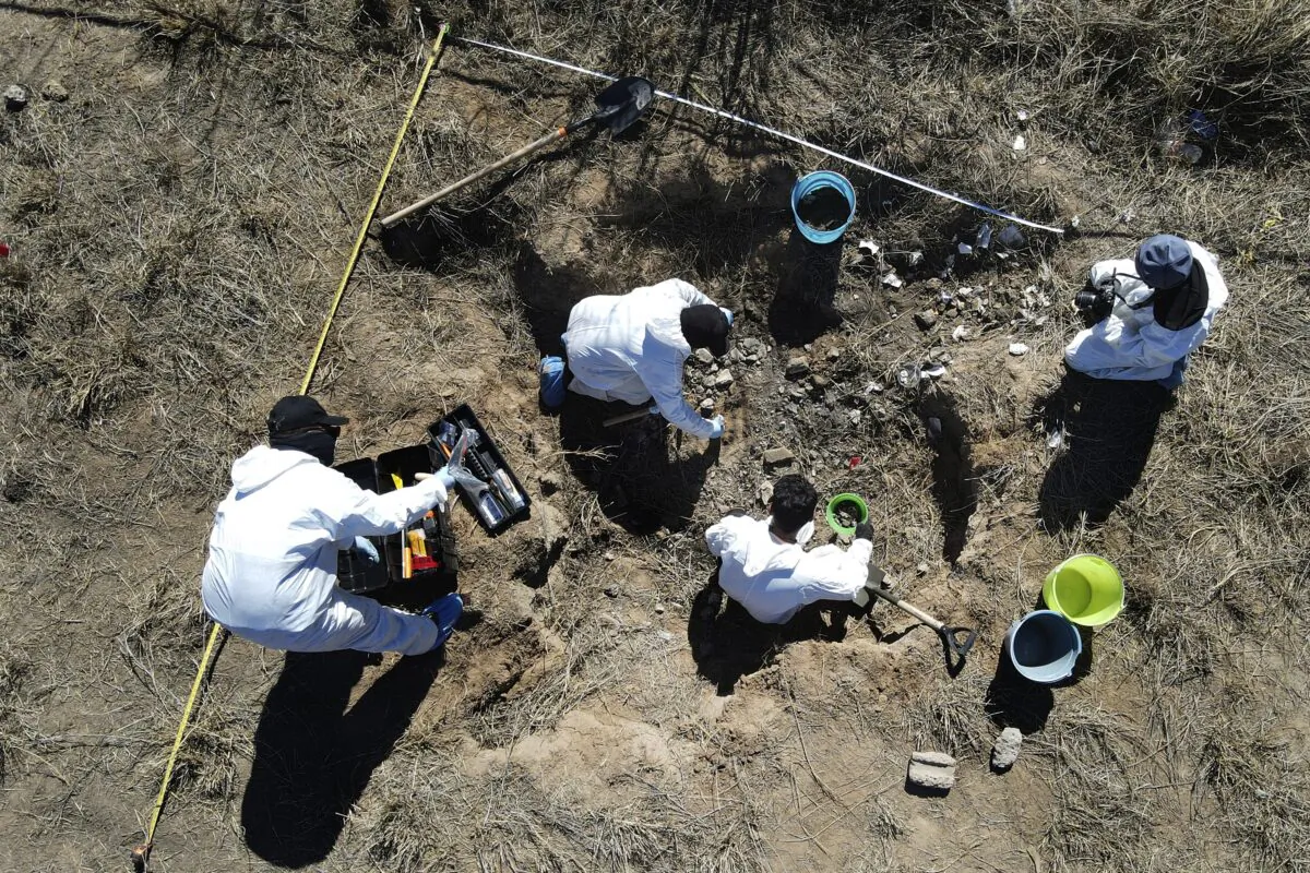 Forensic technicians excavate a field on a plot of land referred to as a cartel "extermination site" where burned human remains are buried, on the outskirts of Nuevo Laredo, Mexico on Feb. 8, 2022. (Marco Ugarte/AP Photo)