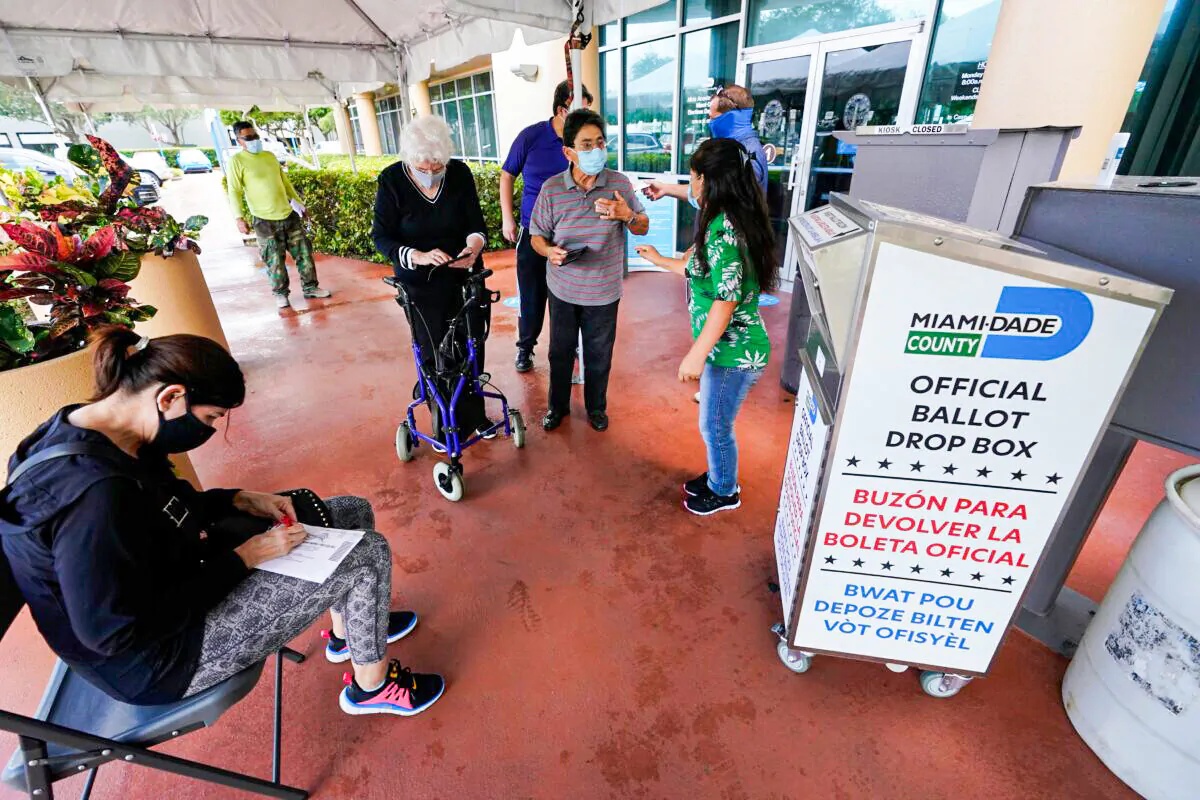 Voters prepare to turn in their mail-in ballot at the Miami-Dade County Elections Department in Doral, Fla., on Oct. 6, 2020. (Wilfredo Lee/AP Photo)