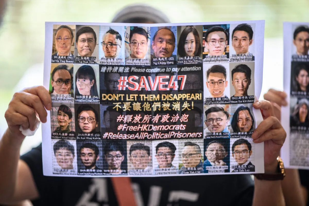 A supporter holds a poster showing some of the 47 pro-democracy activists on trial at the West Kowloon Court in Hong Kong on July 8, 2021, on charges of conspiracy to commit subversion under the National Security Law for taking part in unauthorized pro-democracy primaries in July 2020. (Anthony Kwan/AFP via Getty Images)