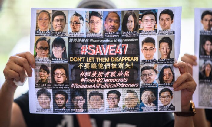 A supporter holds a poster showing some of the 47 pro-democracy activists on trial at the West Kowloon Court in Hong Kong on July 8, 2021, on charges of conspiracy to commit subversion under the National Security Law for taking part in unauthorized pro-democracy primaries in July 2020. (Anthony Kwan/AFP via Getty Images)