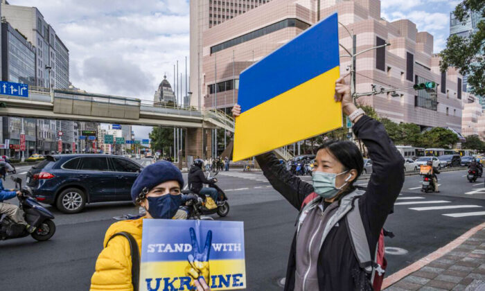 Protesters display placards in front of the Representative Office of the Moscow-Taipei Coordination Commission in Taipei on Feb. 25, 2022, to protest against Russia's military invasion of Ukraine. (Lam Yik Fei/Getty Images)