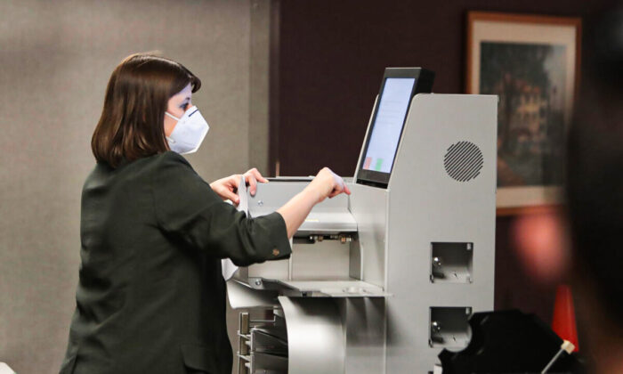 A file photo shows an election worker collecting the count from a voting machine in a file photo of the Nov. 3 election (Scott Olson/Getty Images)
