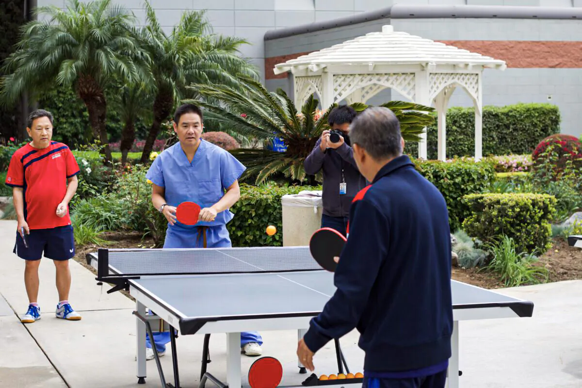 Manh Nguyen plays ping pong with his cardiologist Dr. Michael Chan in Orange, Calif., on March 31, 2022. (Drew Van Voorhis/The Epoch Times)