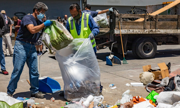 Los Angeles sanitation workers clean up trash left in Venice Beach, Calif., on June 8, 2021. (John Fredricks/The Epoch Times)