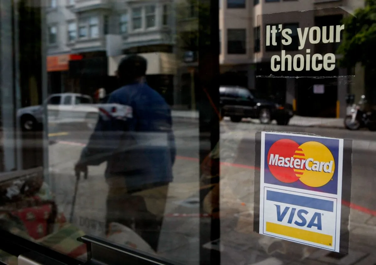 A window sticker advertising Visa and MasterCard credit cards hangs in a window in San Francisco on Feb. 25, 2008. (Justin Sullivan/Getty Images)