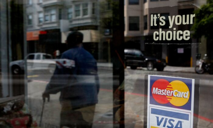 A window sticker advertising Visa and MasterCard credit cards hangs in a window in San Francisco, on Feb. 25, 2008. (Justin Sullivan/Getty Images)