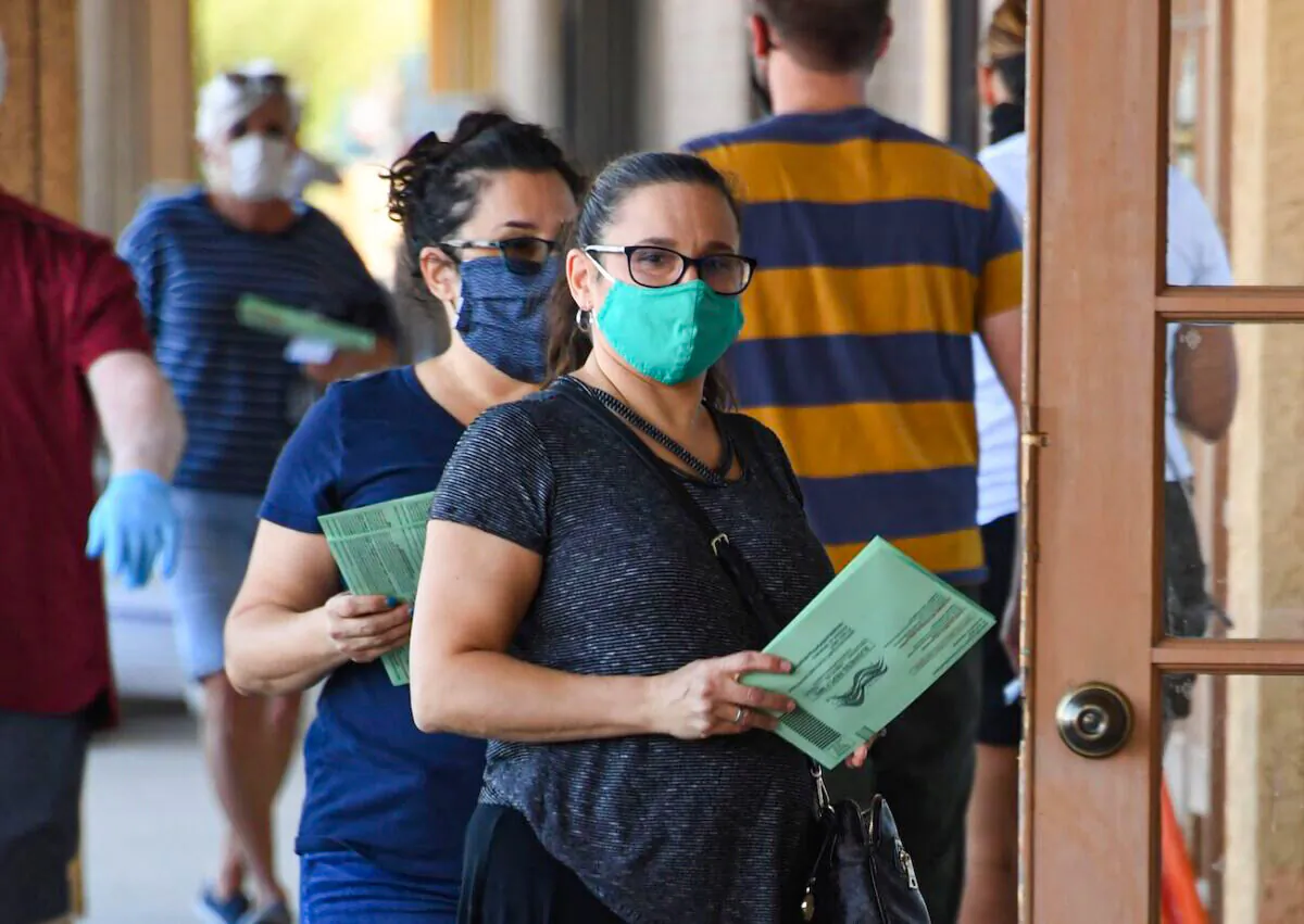People wait in line to drop off mail-in ballots at an early voting location in Phoenix, Ariz., on Oct. 16, 2020. (Robyn Beck/AFP via Getty Images)