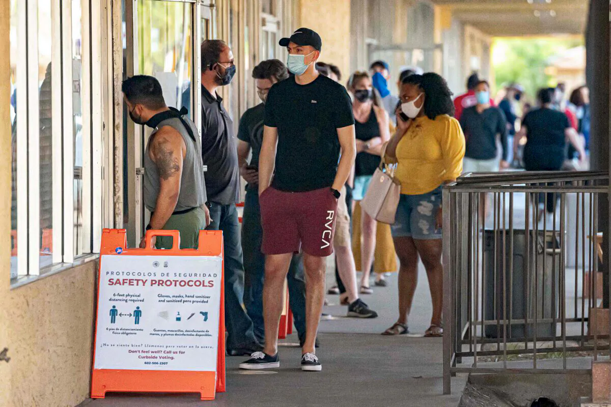 People wait in line to vote at a polling place at the Scottsdale Plaza Shopping Center, in Scottsdale, Ariz., on Nov. 3, 2020. (Olivier Touron/AFP via Getty Images)