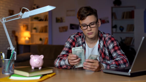 Teenager,Counting,Dollar,Bills,And,Putting,Them,To,Piggyback,,First