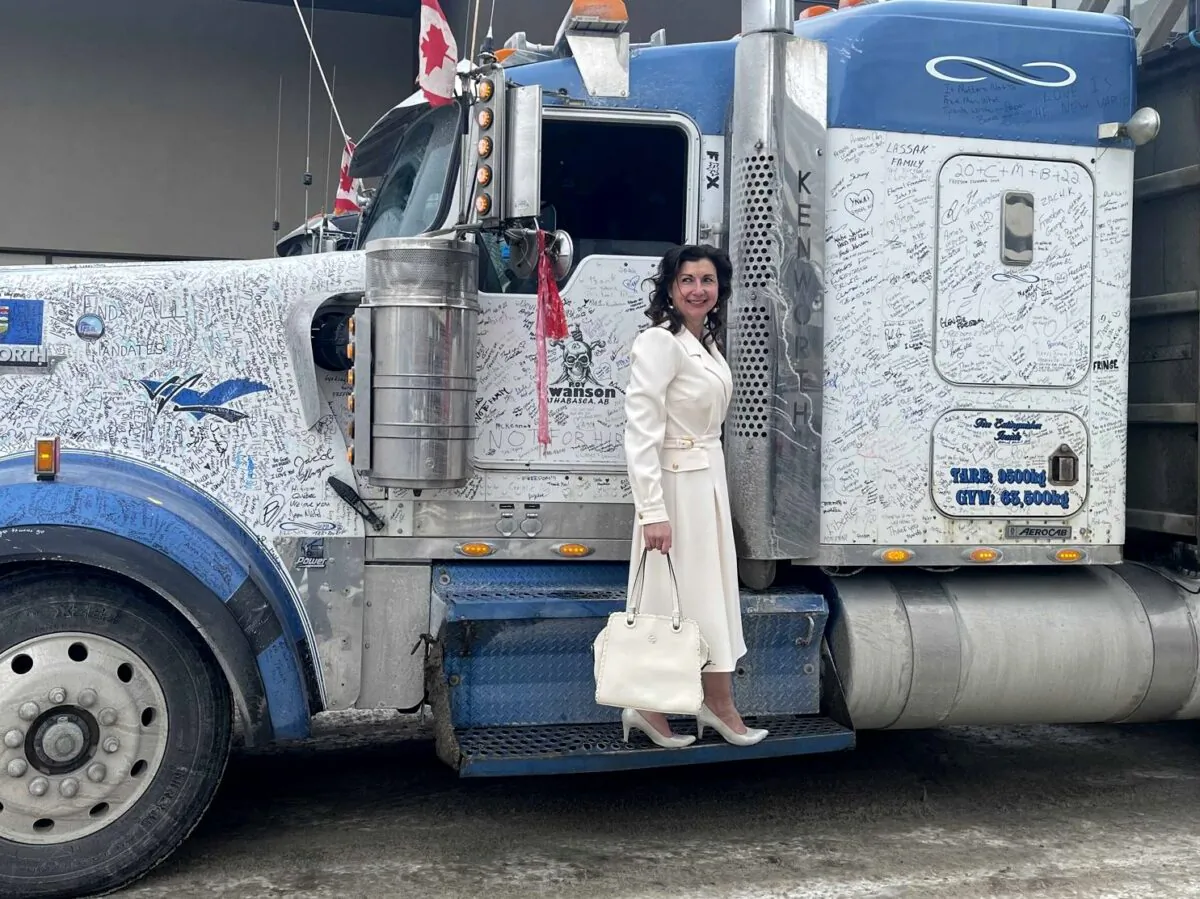 Svetlana Dalla Lana stands on the step of a truck that had returned from the convoy protest in Ottawa, during an Ezra Wellness promotional event in Regina, Saskatchewan, on Feb. 27, 2021. (Courtesy of Svetlana Dalla Lana)