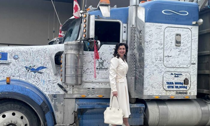 Svetlana Dalla Lana stands on the step of a truck that had returned from the convoy protest in Ottawa, during an Ezra Wellness promotional event in Regina, Saskatchewan, on Feb. 27, 2021. (Courtesy of Svetlana Dalla Lana)