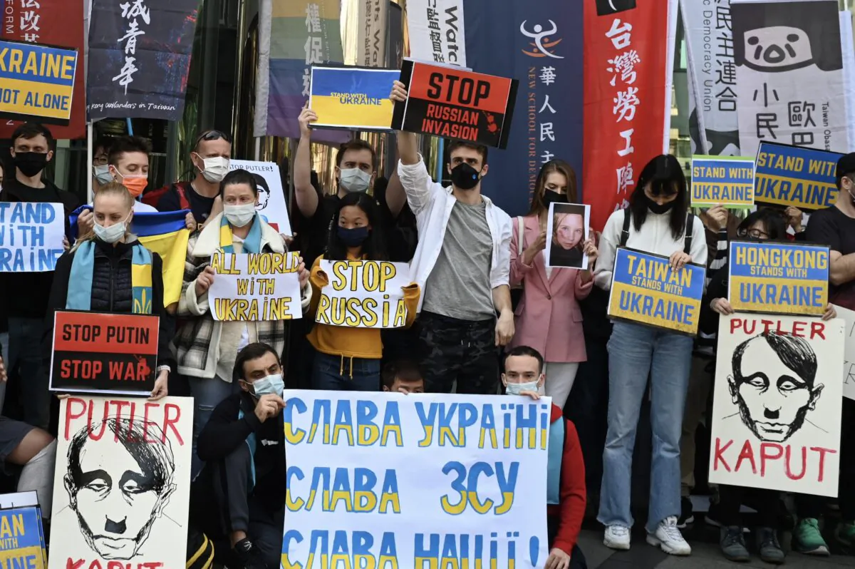 People hold placards during a protest against Russia's invasion of Ukraine, outside the Russian representative office in Taipei on March 1, 2022. (Sam Yeh/AFP via Getty Images)