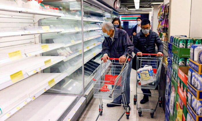 Customers wearing masks shop in front of partially empty shelves at a supermarket during the COVID-19 outbreak in Hong Kong, on Feb. 28, 2022. (Tyrone Siu/Reuters)