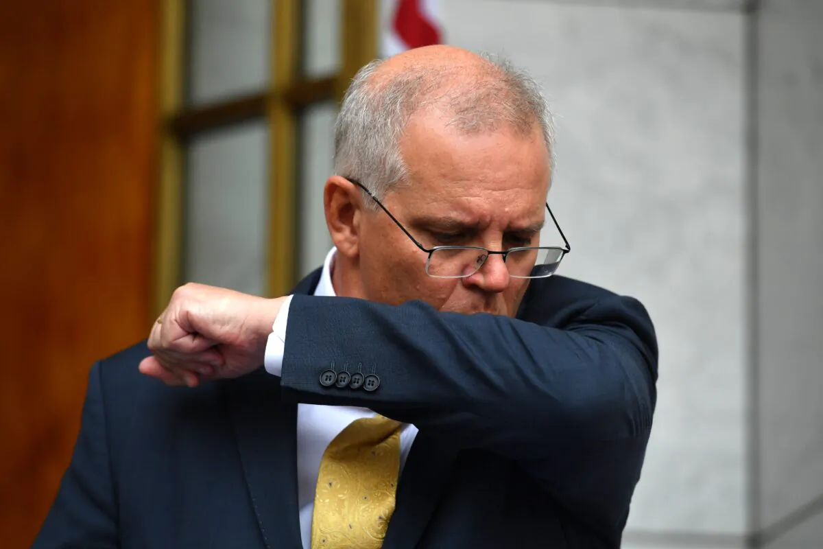Prime Minister Scott Morrison coughs at a press conference after a National Security Committee meeting at Parliament House in Canberra, Australia, on March 1, 2022. (AAP Image/Mick Tsikas)