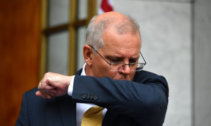 Prime Minister Scott Morrison coughs at a press conference after a National Security Committee meeting at Parliament House in Canberra, Australia, on March 1, 2022. (AAP Image/Mick Tsikas)