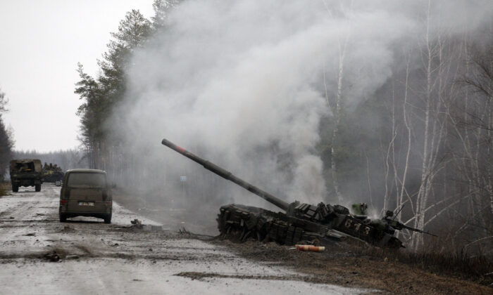 Smoke rises from a Russian tank destroyed by the Ukrainian forces on the side of a road in Lugansk region, Ukraine on Feb. 26, 2022. (Anatolii Stepanov/AFP via Getty Images)