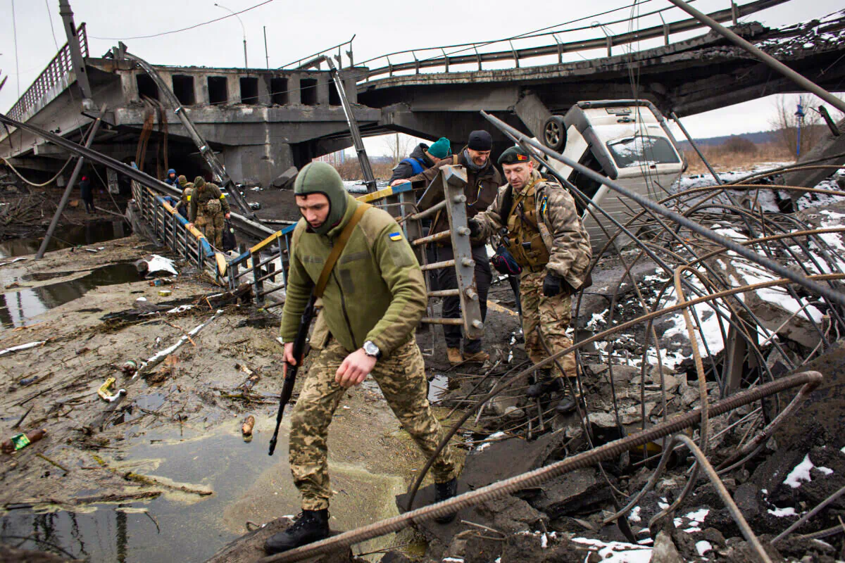 Ukrainian serviceman cross the destroyed bridge in Irpin, Ukraine, on March 1, 2022. (Anastasia Vlasova/Getty Images)