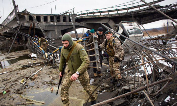 Ukrainian serviceman cross the destroyed bridge in Irpin, Ukraine, on March 1, 2022. (Anastasia Vlasova/Getty Images)