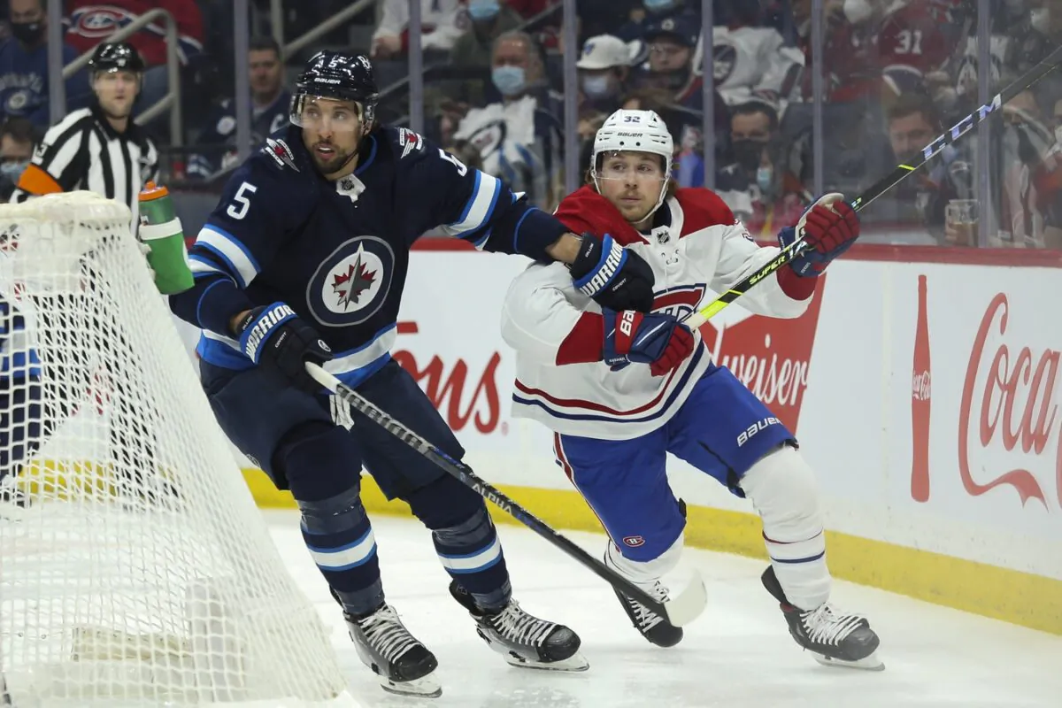 Montreal Canadiens forward Rem Pitlick (32) and Winnipeg Jets defenseman Brenden Dillon (5) skate after the puck during the first period at Canada Life Centre in Winnipeg, Manitoba, Canada, on Mar 1, 2022. (Terrence Lee/USA TODAY Sports via Field Level Media)