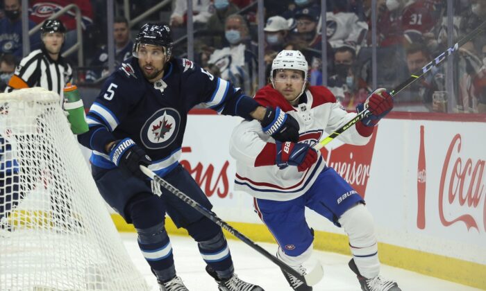 Montreal Canadiens forward Rem Pitlick (32) and Winnipeg Jets defenseman Brenden Dillon (5) skate after the puck during the first period at Canada Life Centre in Winnipeg, Manitoba, Canada, on Mar 1, 2022. (Terrence Lee/USA TODAY Sports via Field Level Media)