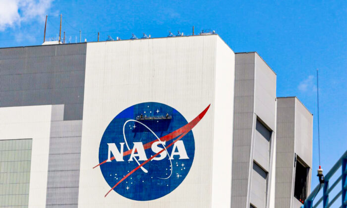 Workers pressure wash the logo of NASA on the Vehicle Assembly Building at the Kennedy Space Center in Cape Canaveral, Fla., on May 19, 2020. (Joe Skipper/Reuters)