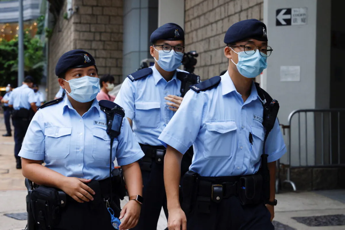 Police stand guard as a prison van arrives at High Court on the first day of trial of Tong Ying-kit, the first person charged under a new national security law, in Hong Kong, on June 23, 2021. (Tyrone Siu/Reuters)
