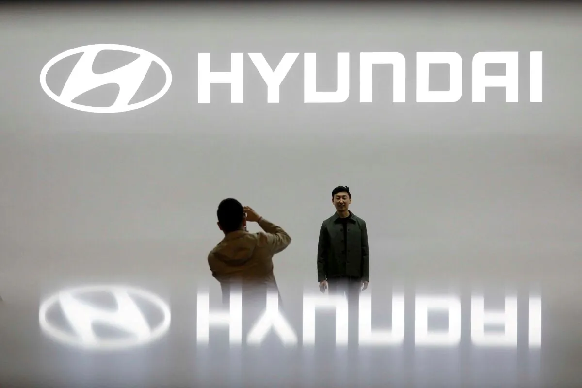Visitors take photographs in front of the logo of Hyundai Motor during the 2019 Seoul Motor Show in Goyang, South Korea, 0n March 28, 2019. (Kim Hong-Ji/Reuters)