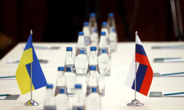 Russian and Ukrainian flags are seen on a table before the talks between officials of the two countries in the Gomel region, Belarus on Feb. 28, 2022. (Sergei Kholodilin/BelTA via Reuters)