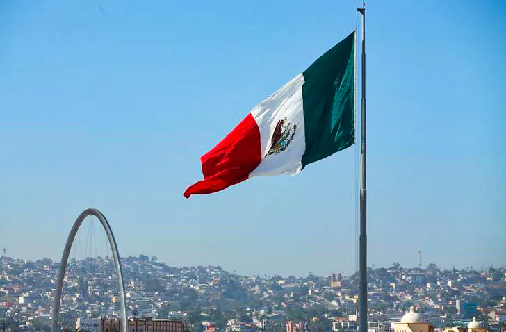 A Mexican flag is seen over the city of Tijuana, Mexico from San Ysidro, a district of San Diego, California, U.S., April 21, 2017.  REUTERS/Mike Blake
