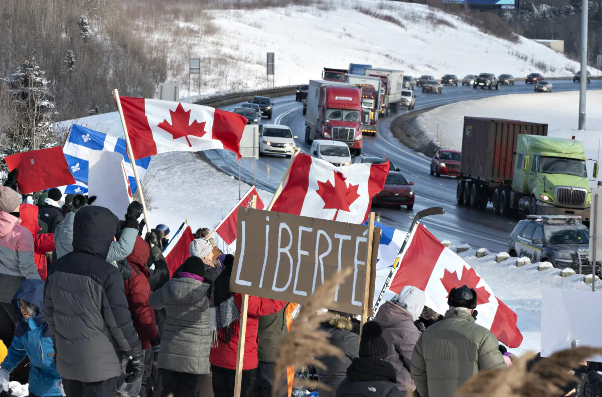 Hundreds of people gather by TransCanada Highway 20 to show their support to truckers heading to Ottawa to protest against COVID-19 restrictions in Levis, Quebec, on Jan. 28, 2022. (Jacques Boissinot/The Canadian Press)