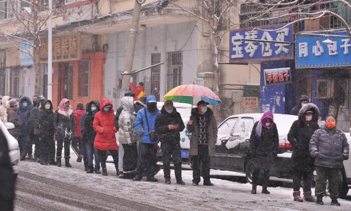 People in line to undergo a nasal swab for nucleic acid testing for COVID-19 as it snows in Harbin in Heilongjiang Province on Mar. 2, 2022. (STR/AFP via Getty Images)
