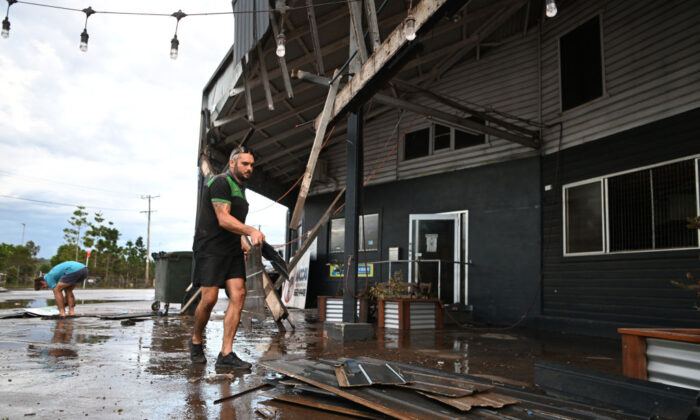 A man removes debris from his flood-affected car mechanic business in Lismore, Australia, on March 2, 2022. (Dan Peled/Getty Images)