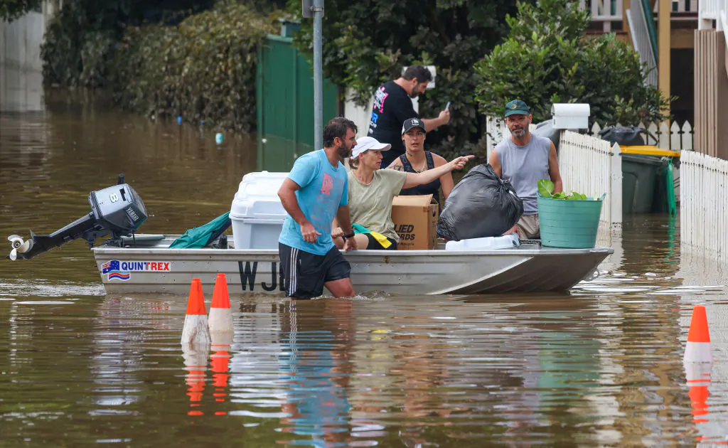 People use a boat to save their belonging from a flooded home at Torwood Street, Auchenflower in Brisbane, Australia, on March 3, 2022. (Peter Wallis/Getty Images)