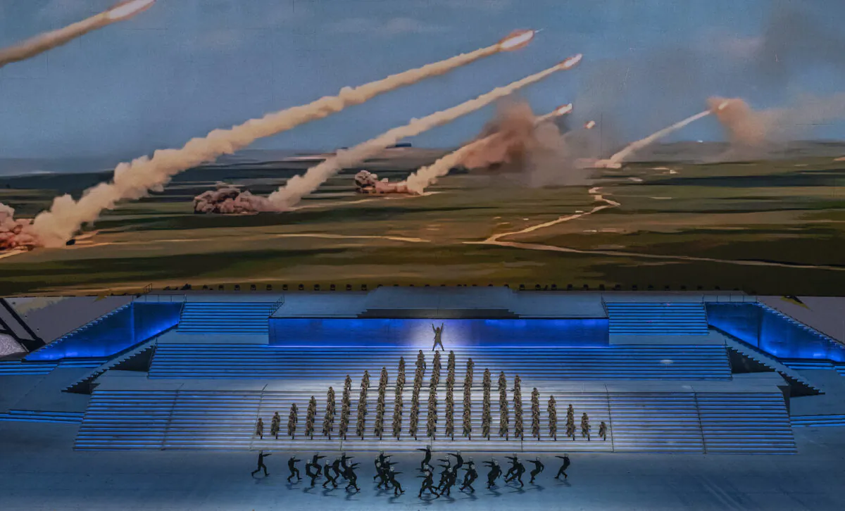 Performers dressed as military perform in front of a screen showing rockets being launched during a mass gala marking the 100th anniversary of the founding of the Communist Party at the Olympic Bird's Nest stadium in Beijing on June 28, 2021. (Kevin Frayer/Getty Images)