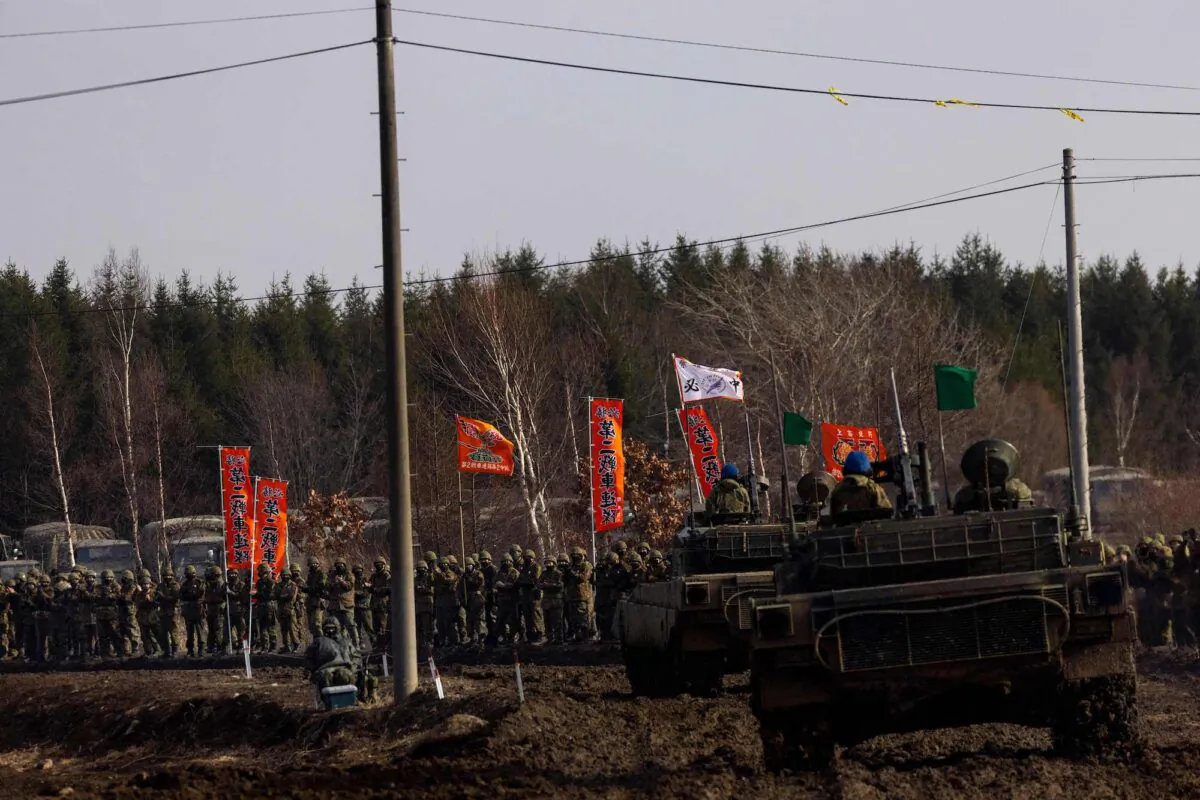 Members of Japan Ground Self-Defense Force Northern Army applaud their comrades after participating in a Type-90 tank live firing competition at the Hokkaido Great Maneuvering Ground in Eniwa, Hokkaido Prefecture, on Dec. 7, 2021. (Behrouz Mehri/AFP via Getty Images)