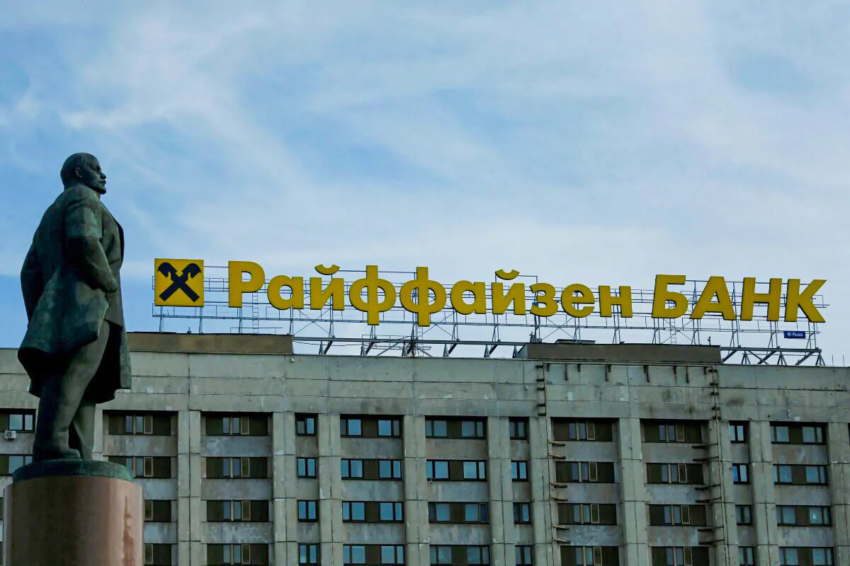 The logo of Raiffeisen Bank on top of a building is seen behind a statue of Soviet state founder Vladimir Leninin in Moscow, on June 14, 2016. (Maxim Shemetov/Reuters)