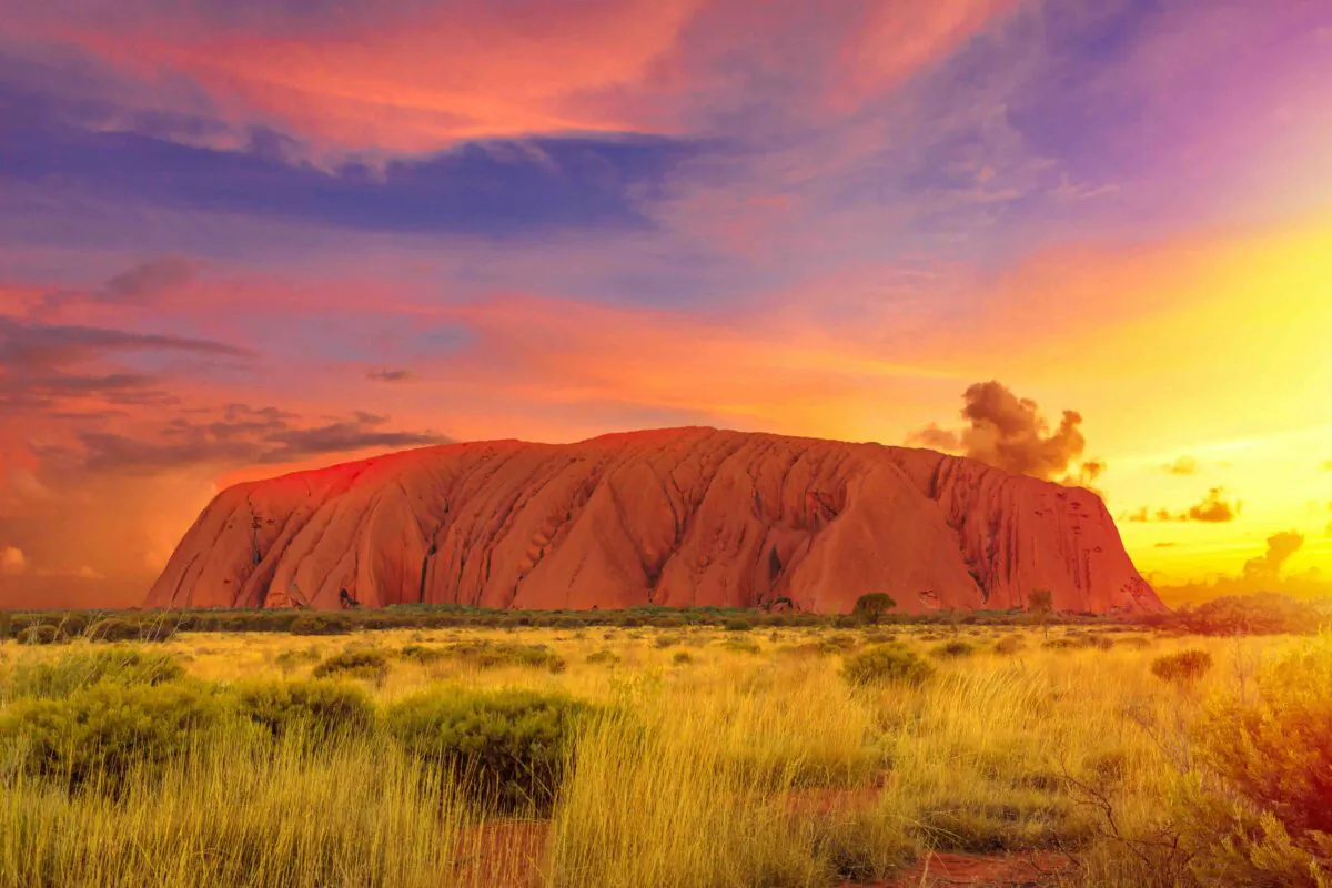 Uluru, Northern Territory, Australia - Aug 22, 2019: Colorful clouds at sunset sky over Ayers Rock in Uluru-Kata Tjuta National Park, Living Cultural Landscape. Majestic Australian outback Red Center. (Benny Marty/Shutterstock)