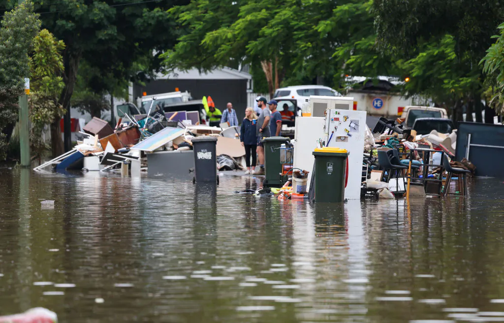People look on as rubbish is placed at a flooded Vincent Street, Auchenflower in Brisbane, Australia on March 03, 2022 . (Photo by Peter Wallis/Getty Images)