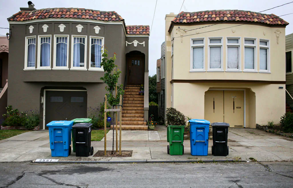 Trash, recycling, and compostable material bins sit in front of homes in a Sunset district neighborhood in San Francisco, Calif., on June 11, 2009. (Justin Sullivan/Getty Images)