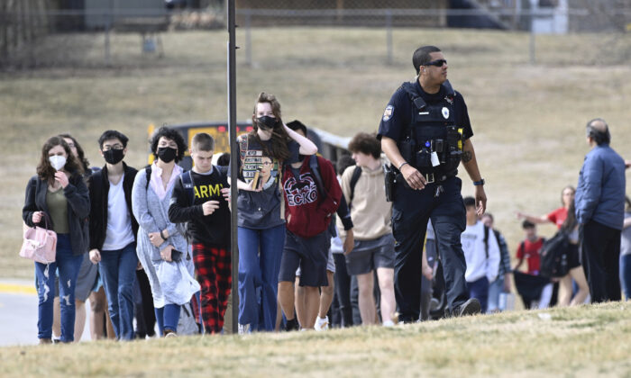 Students from Olathe East High school are led off busses to reunite with their parents, at Pioneer Trail Middle School in Olathe, Kan., on March 4, 2022. (Reed Hoffmann/The Kansas City Star via AP)