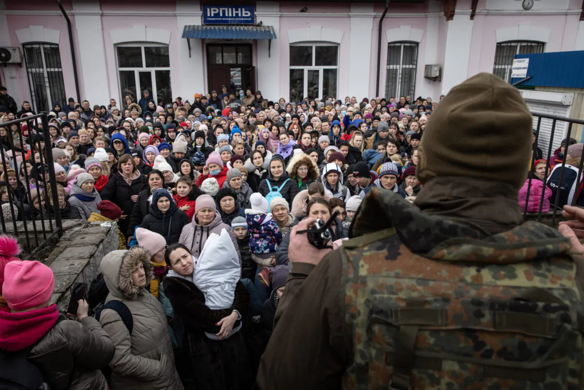 A member of the Ukrainian military gives instructions to women and children that fled fighting in Bucha and Irpin before boarding an evacuation train from Irpin City to Kyiv that was scheduled after heavy fighting forced many to leave their homes, in Irpin, Ukraine, on March 4, 2022. (Chris McGrath/Getty Images)