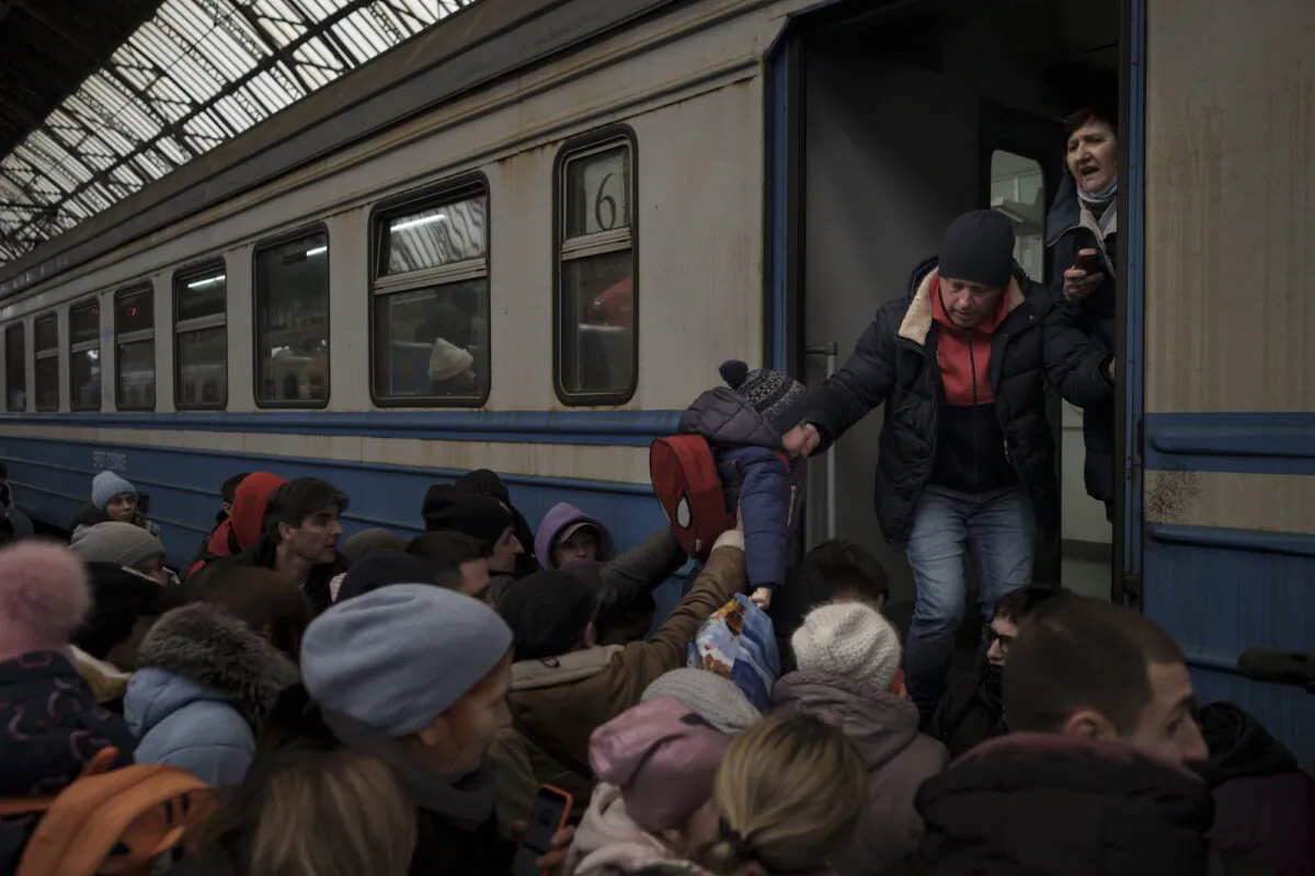 Passengers rush to board a train leaving to Slovakia from the Lviv railway station, in Lviv, Ukraine, on March 2, 2022. (Felipe Dana/AP Photo)