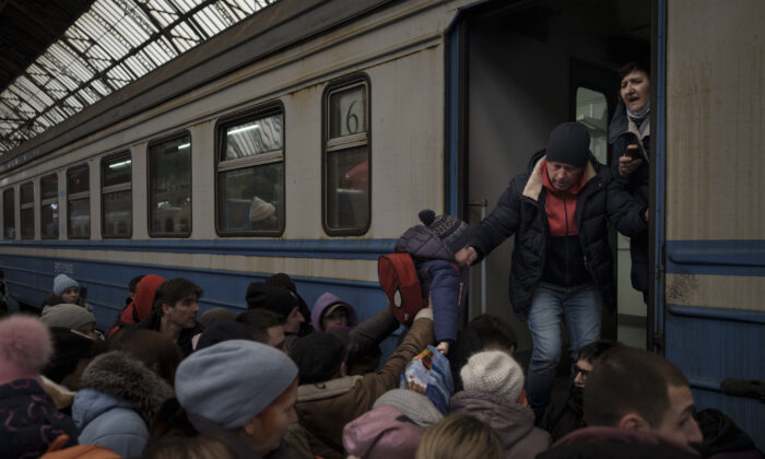 Passengers rush to board a train leaving to Slovakia from the Lviv railway station, in Lviv, Ukraine, on March 2, 2022. (Felipe Dana/AP Photo)