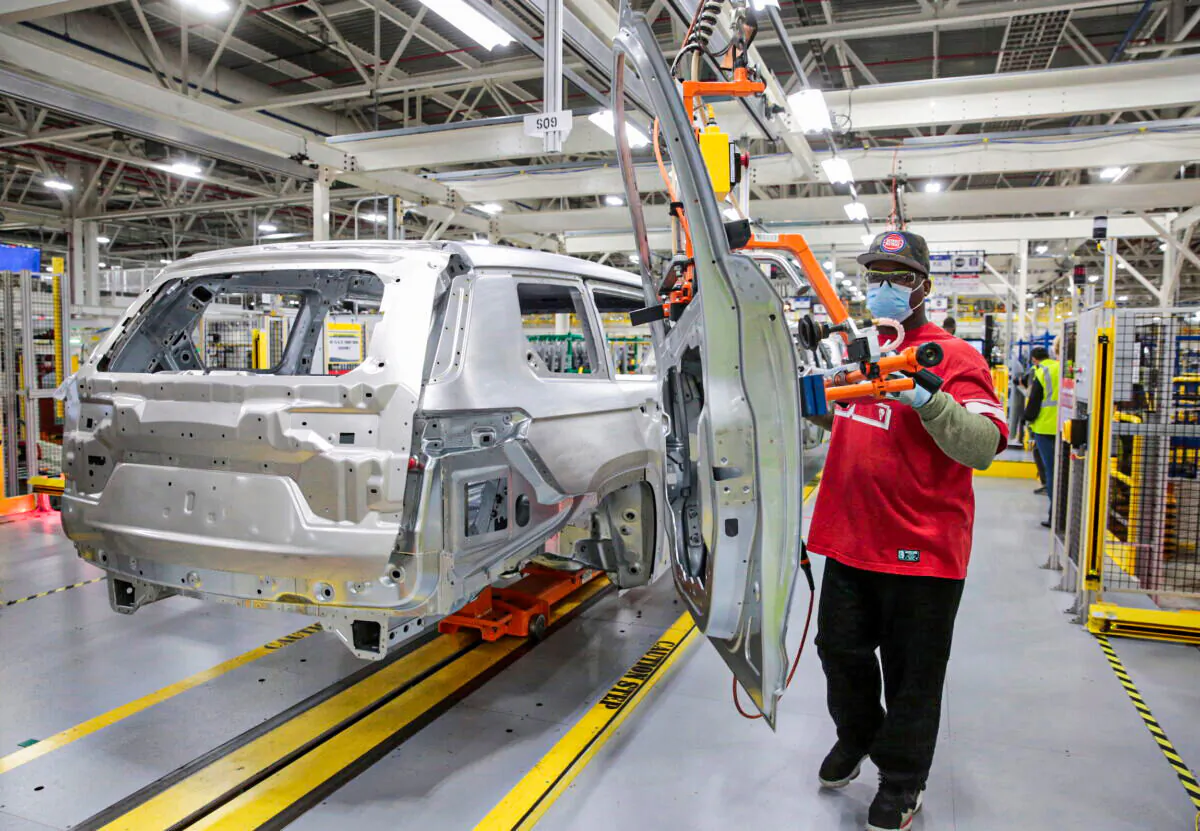 A Stellantis assembly worker installs the door frame to a 2021 Jeep Grand Cherokee L on the assembly line at the Detroit Assembly Complex - Mack Plant in Detroit, on June 10, 2021. (Rebecca Cook/Reuters)