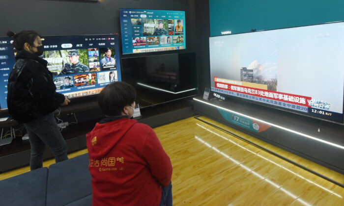 Residents watch a TV screen showing news about conflict between Russia and Ukraine at a shopping mall in Hangzhou, in China's eastern Zhejiang province on February 25, 2022.(STR/AFP via Getty Images)