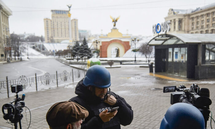 Journalists are seen working on the doorstep of an hotel on Maidan Square in Kyiv, Ukraine, on March 1, 2022. (Pierre Crom/Getty Images)