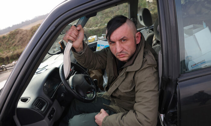 Roman, 35, a Ukrainian living in Poland, displays his knife as he waits to cross into Ukraine to join the armed resistance against the Russian invasion at the Medyka border crossing in Medyka, Poland, on March 4, 2022. (Sean Gallup/Getty Images)